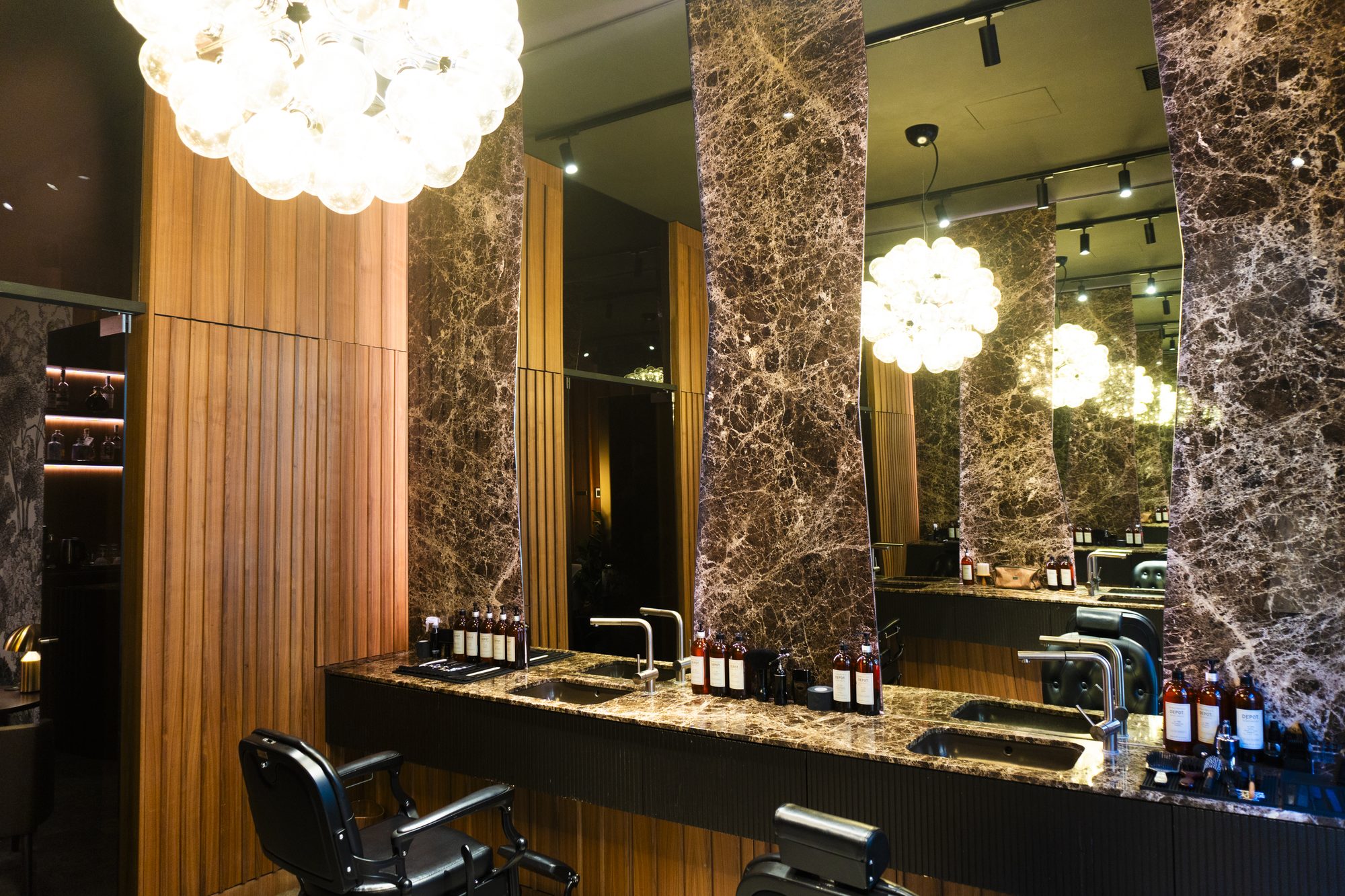 Interni del salone Jenny B: marmo Dark Emperador, noce Canaletto, lampadario Flos Taraxacum
